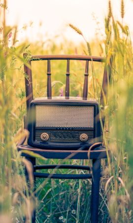 image de radio ancienne posee sur une chaise en exterieur