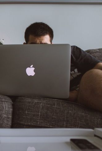 image de personne regardant son ordinateur portable allongee sur un canape